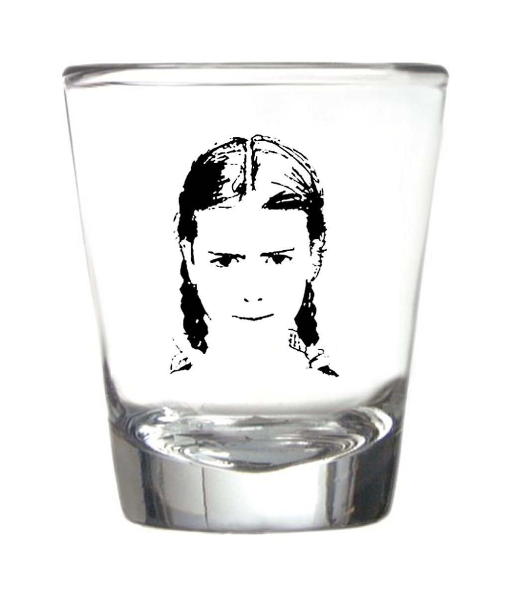 A black line drawing on a shot glass of a serious looking young girl with pigtails.