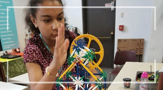 A young girl building a machine