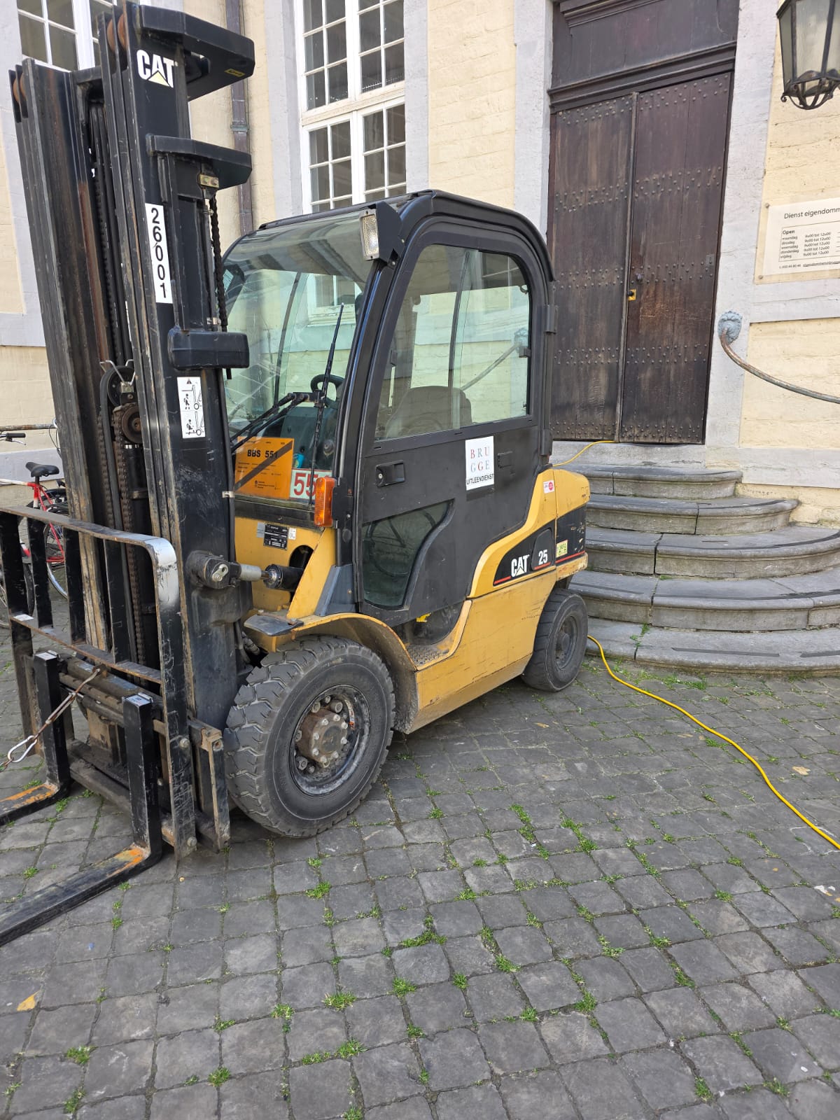 Persona de espaldas con trípode en el hombro observando un paisaje montañoso y nublado.