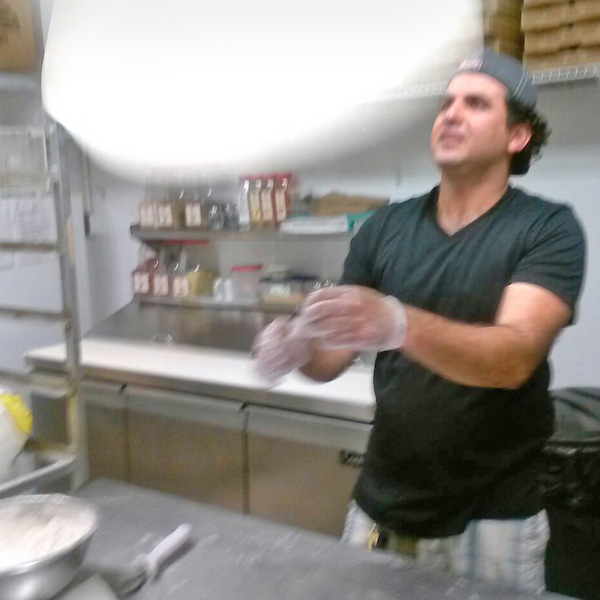 A Man Tossing a Pizza Dough