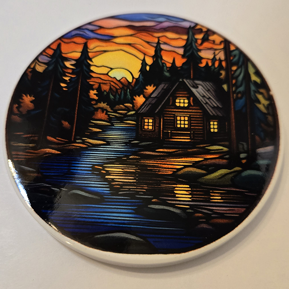Round ceramic coaster with a stained glass cabin design