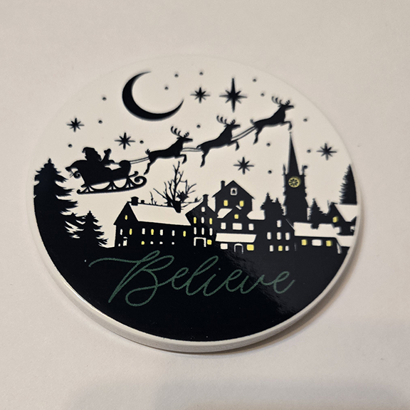 Round ceramic coaster with a believe in Santa design