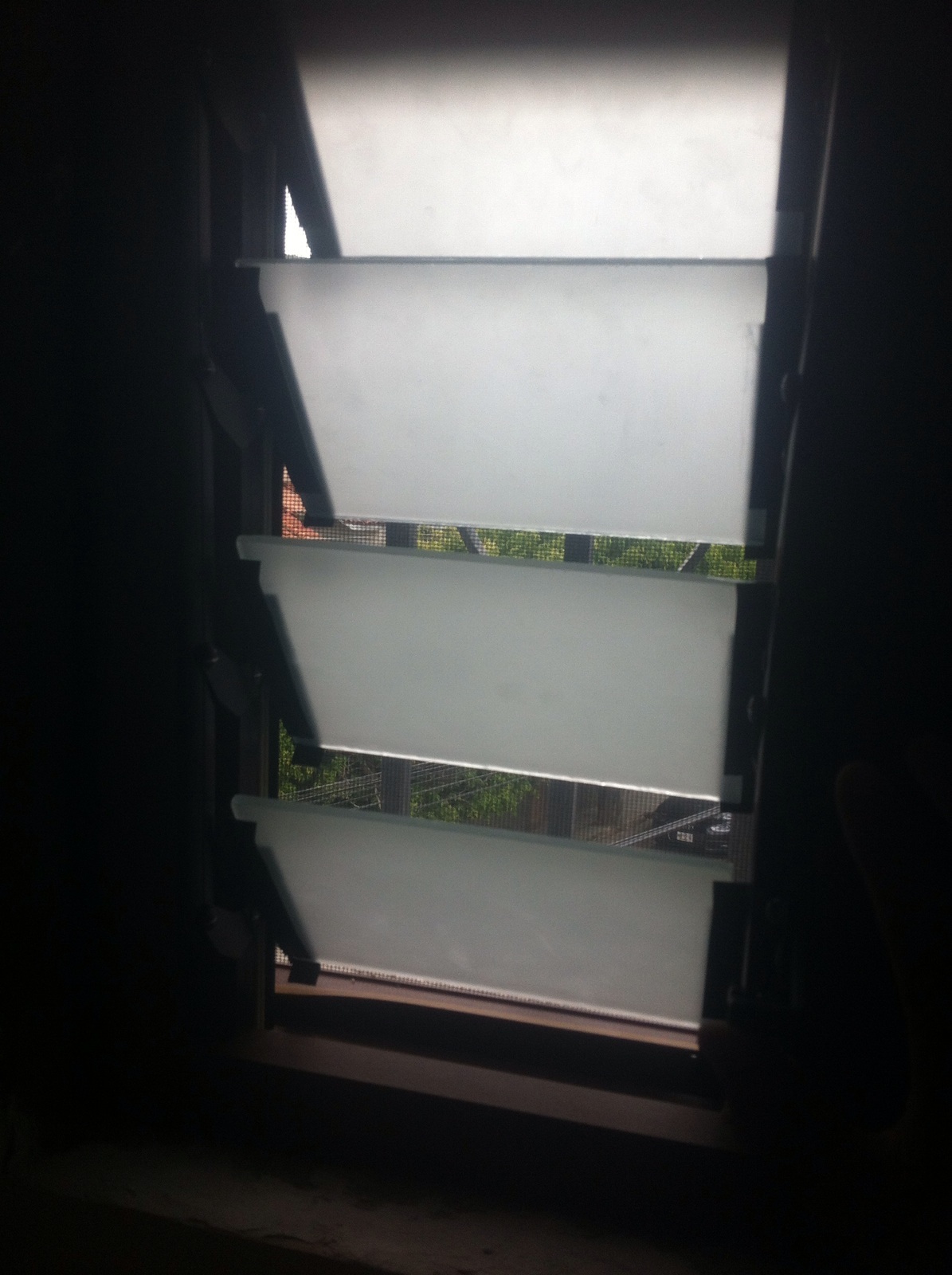 Ventana con persiana en tono madera y vidrio satinado.