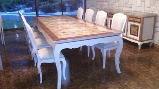 Sala moderna con sofá beige, estanterías de madera, mesa de centro y ventana panorámica con vista al jardín.