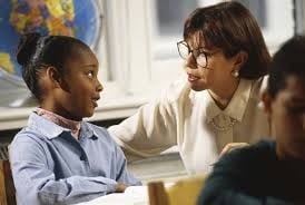 Teacher comforting young student in a classroom during a discussion