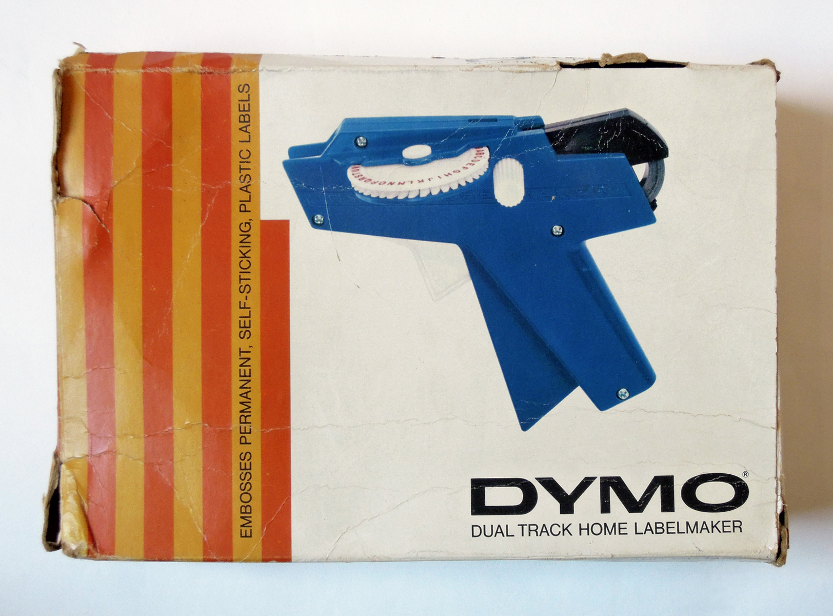 A vintage Dymo “dual track home labelmaker” box in white, orange and blue.