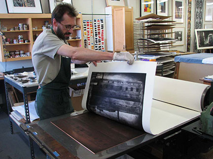 Printer David Avery pulling a print of Jenny Robinson's Third Street Factory