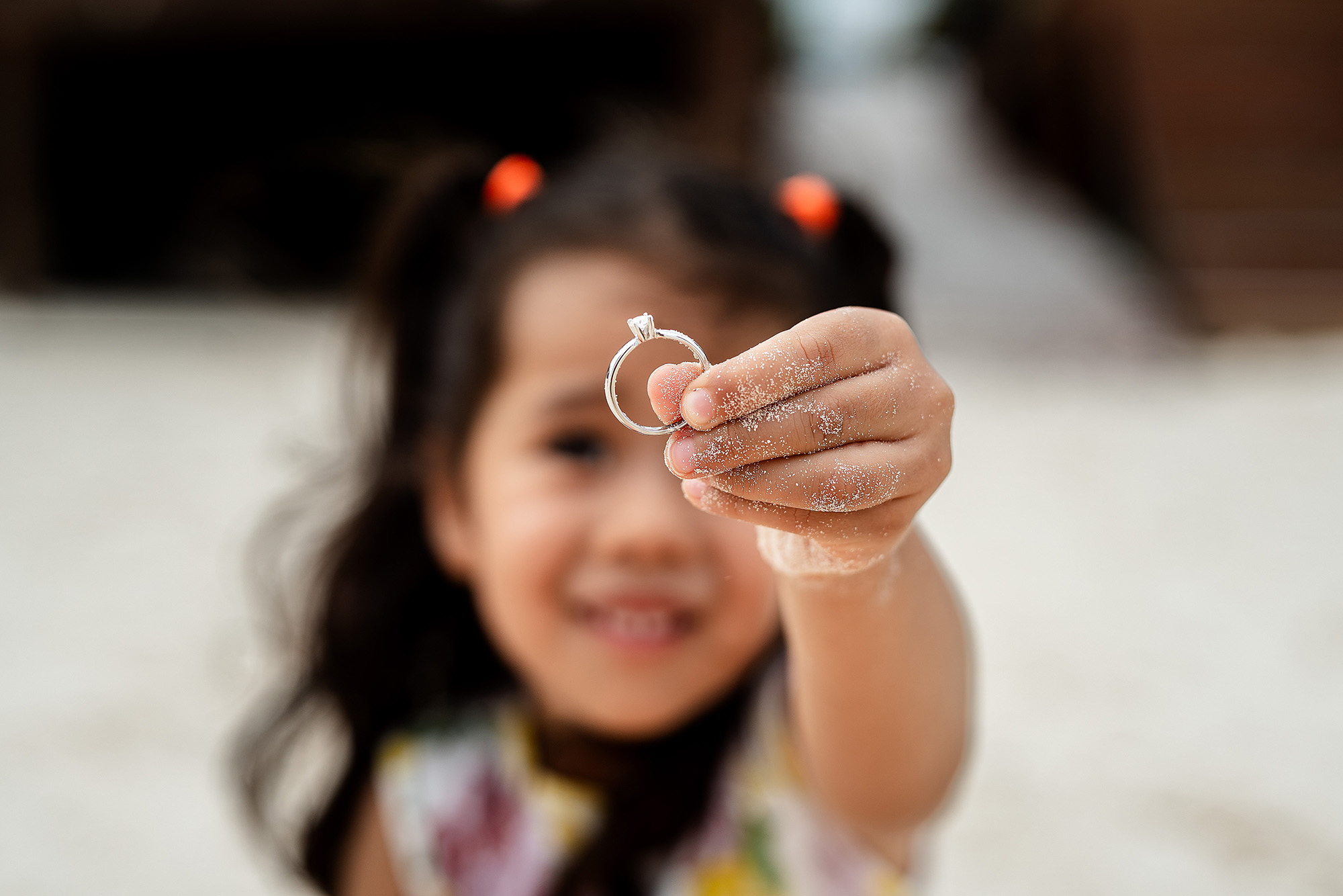 Detalle del anillo de compromiso en la playa de Puerto Morelos, hija agarrando el anillo de compromiso.