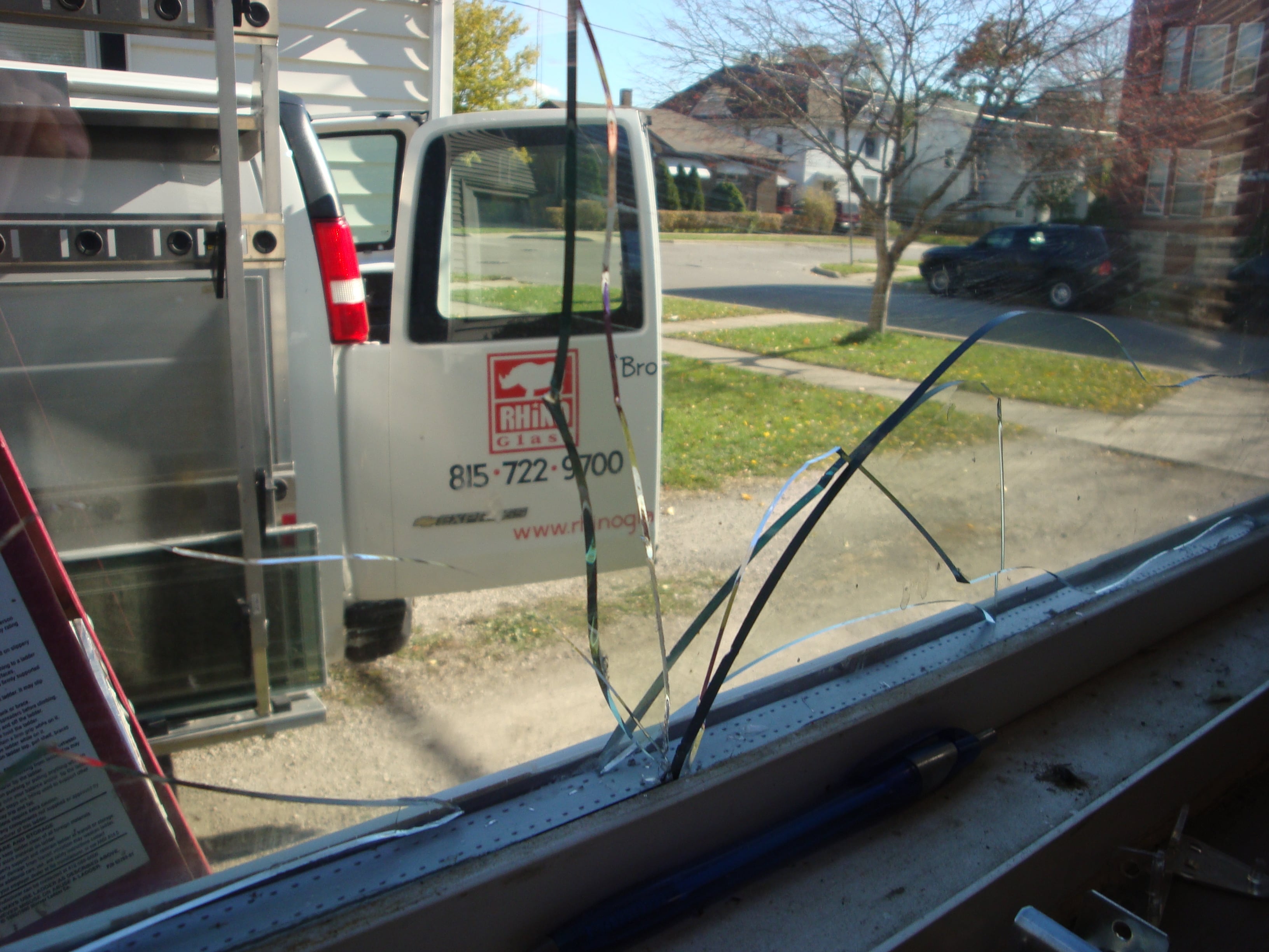 Modern patio with potted plants and large glass doors in a sunlit area.