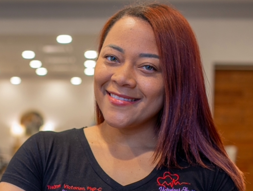 Modern open-plan kitchen and living area with large windows, neutral decor, wooden flooring, and indoor plants, featuring sleek cabinetry and a spacious dining setup.