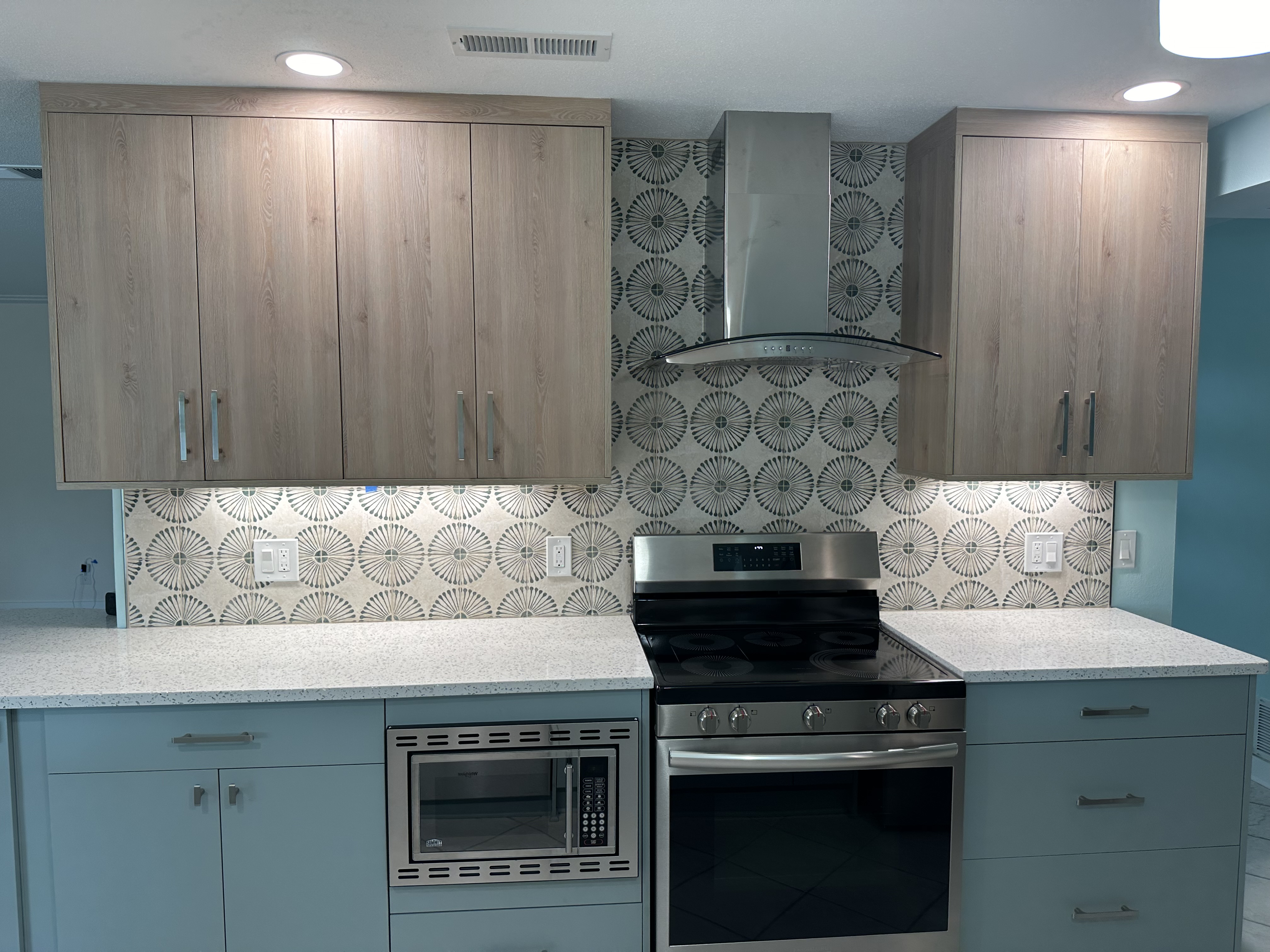 The undercabinet lighting visually highlights the unique and fun backsplash and countertop.