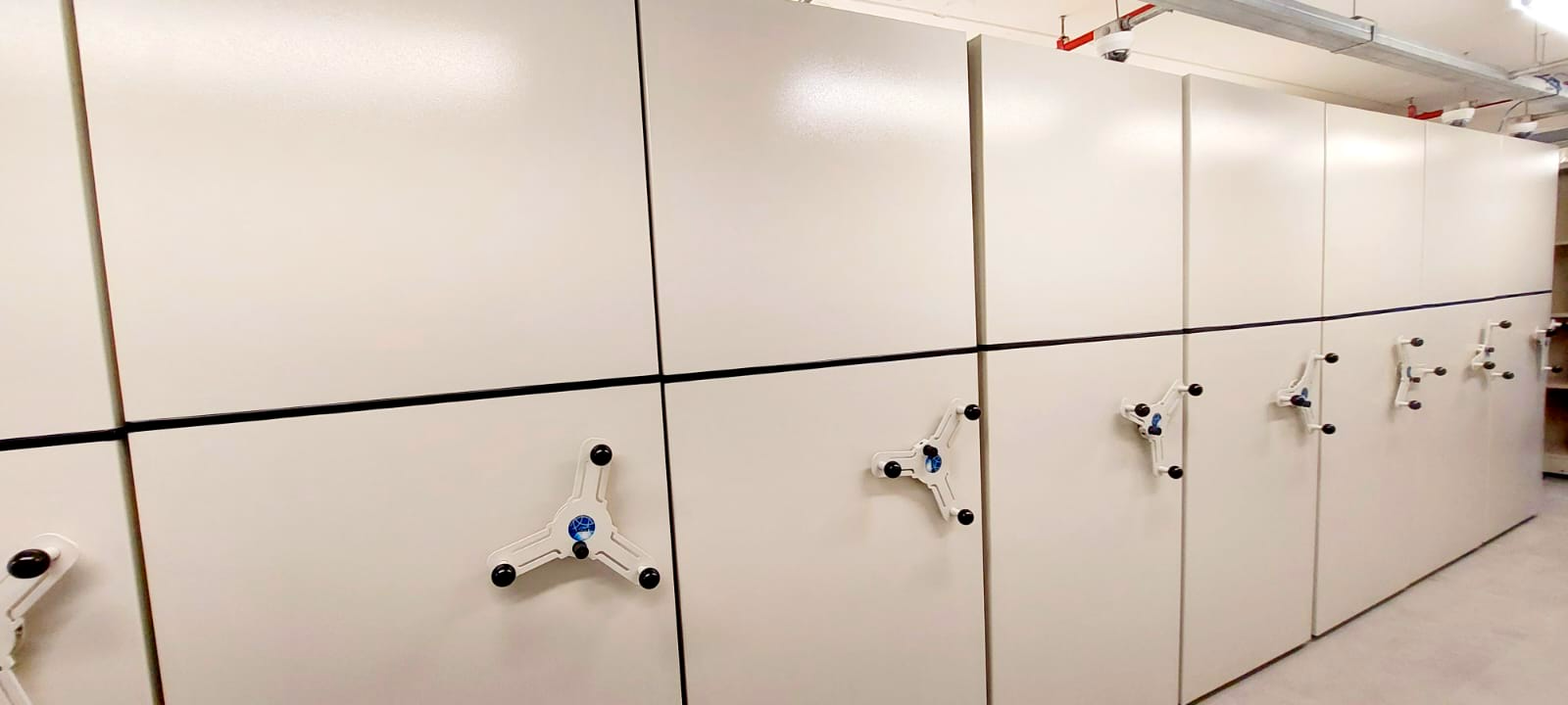 Sistema de arquivos deslizante branco em uma sala de armazenamento.