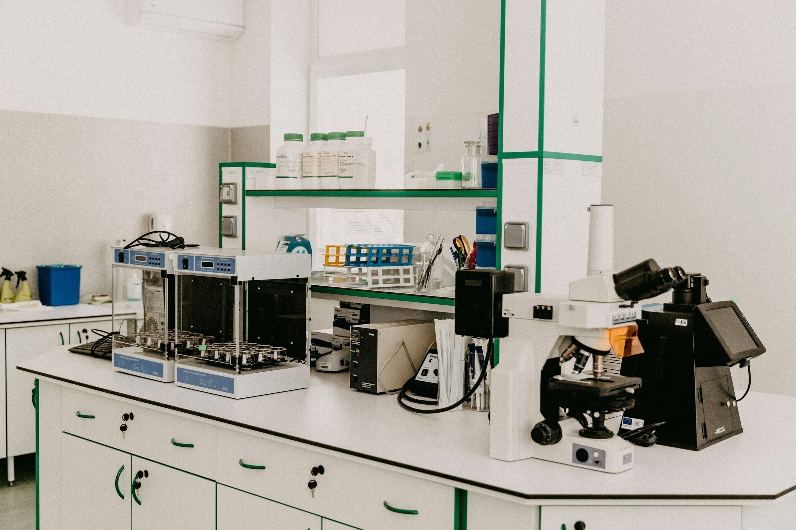 Laboratorio moderno con equipos científicos, incluyendo microscopio y materiales de análisis en una mesa blanca.