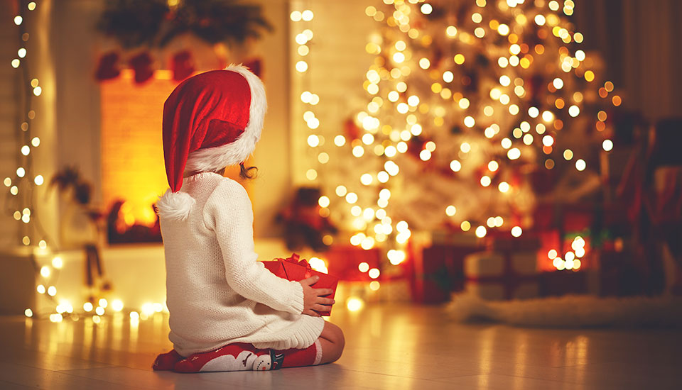 Child Girl Sitting Back in Front of Christmas Tree on Christmas Eve