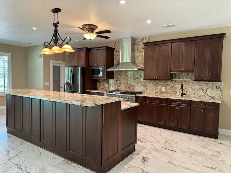 This spacious kitchen features beautiful semi-custom maple wood cabinetry-stained Ginger Snap and brush nickel handles and knobs.