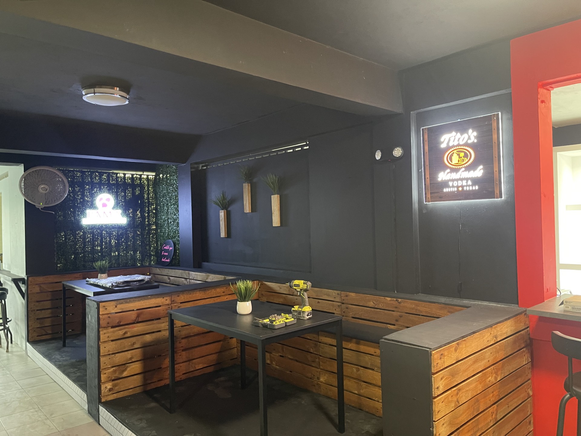 dos mesas cuadradas de madera marrón cerca de una pared de ladrillo marrón