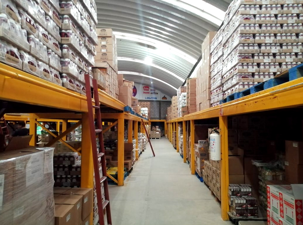 Pasillo de supermercado con estantes llenos de productos envasados multicolores.