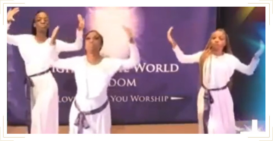 3 women wearing white with their hands in the air