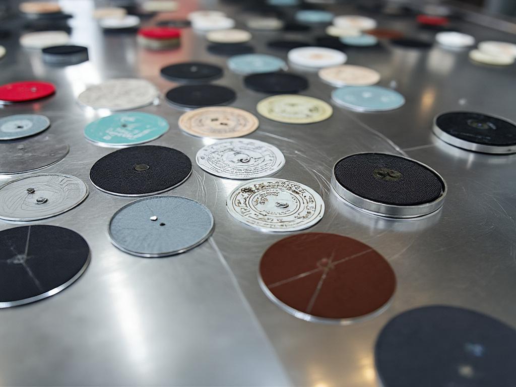 Varios discos de vinilo de colores en una superficie metálica.