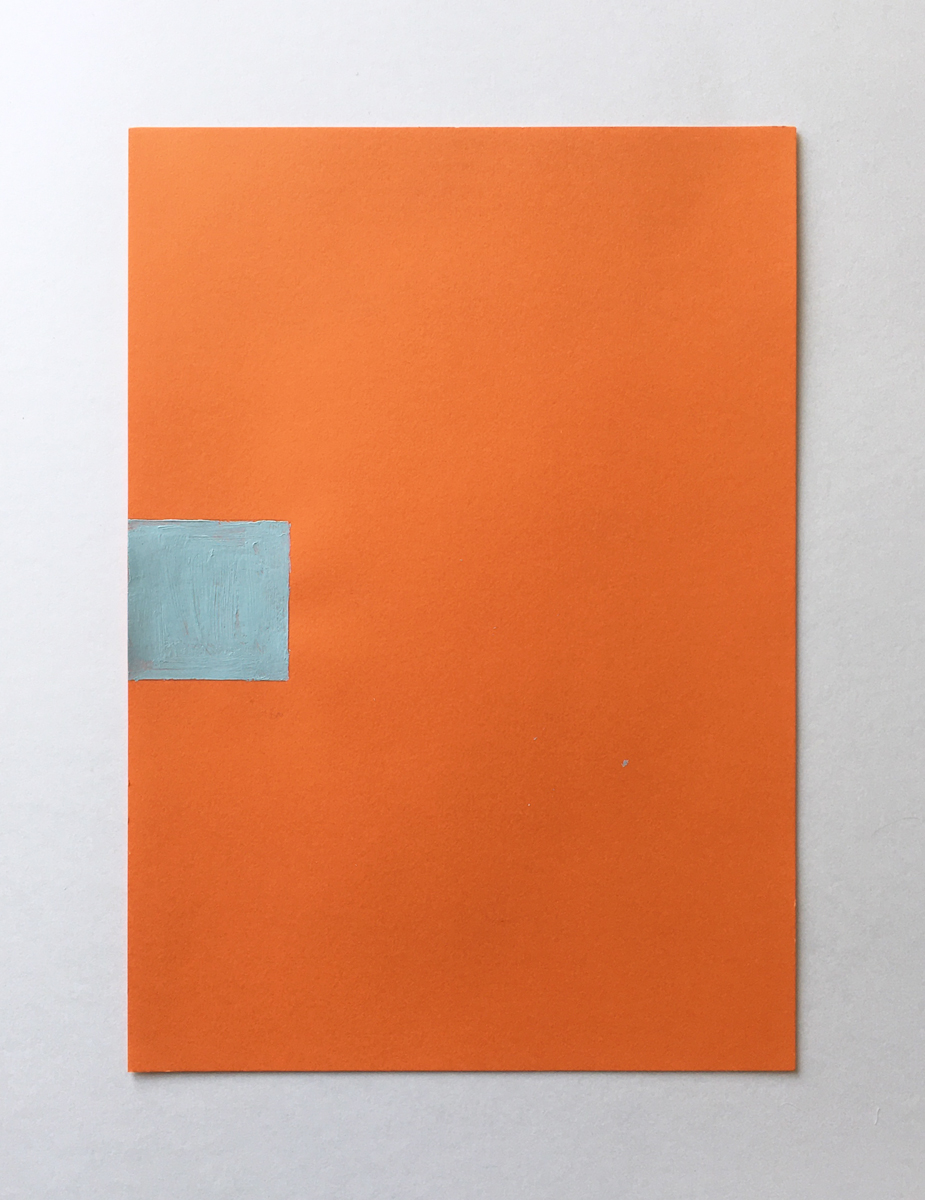 An orange piece of paper with a small square of light blue paint halfway up.
