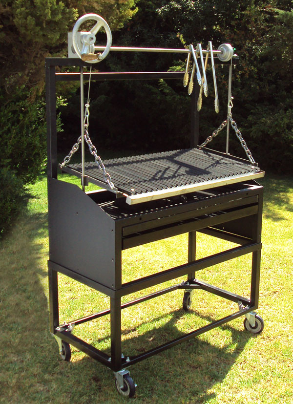 Parrilla de asado con sistema de elevación manual sobre césped verde, ideal para barbacoas al aire libre.