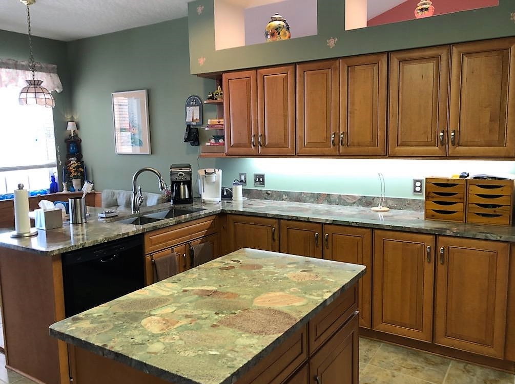 Serene kitchen featuring beautiful wood-stained cabinetry with brush nickel hardware. 