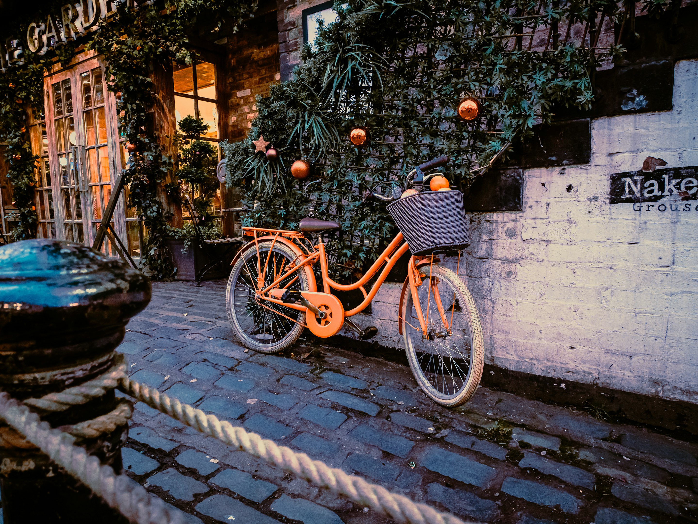 una bicicleta naranja aparcada junto a un edificio