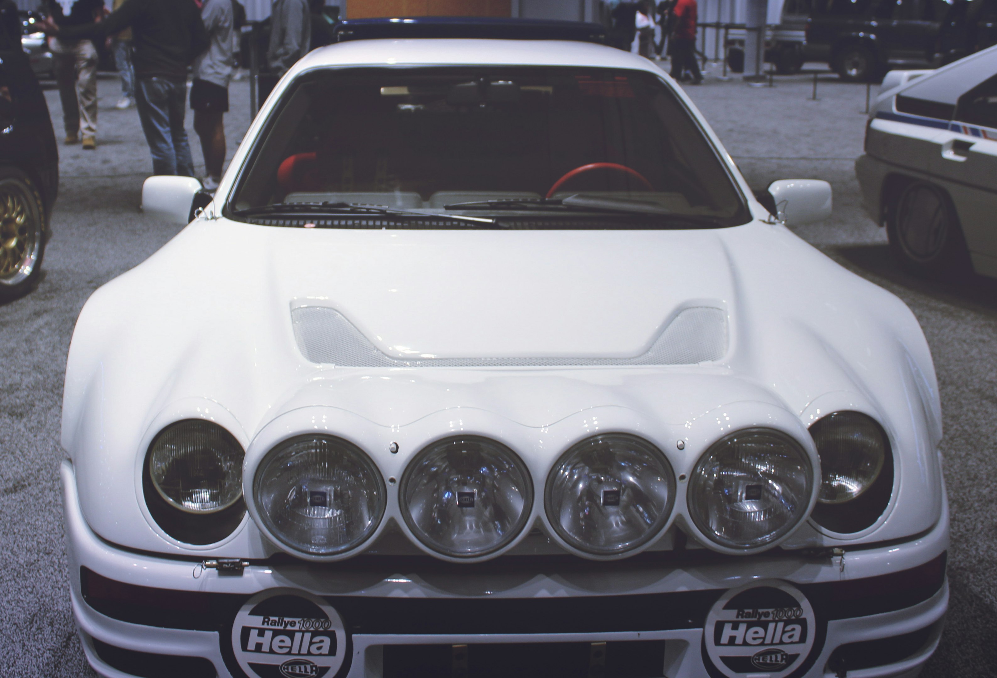 a white car parked in a parking lot next to other cars