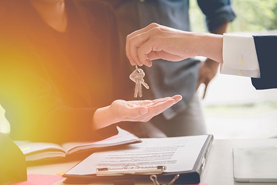 Hands Of Estate Agent Giving Keys To The Couple