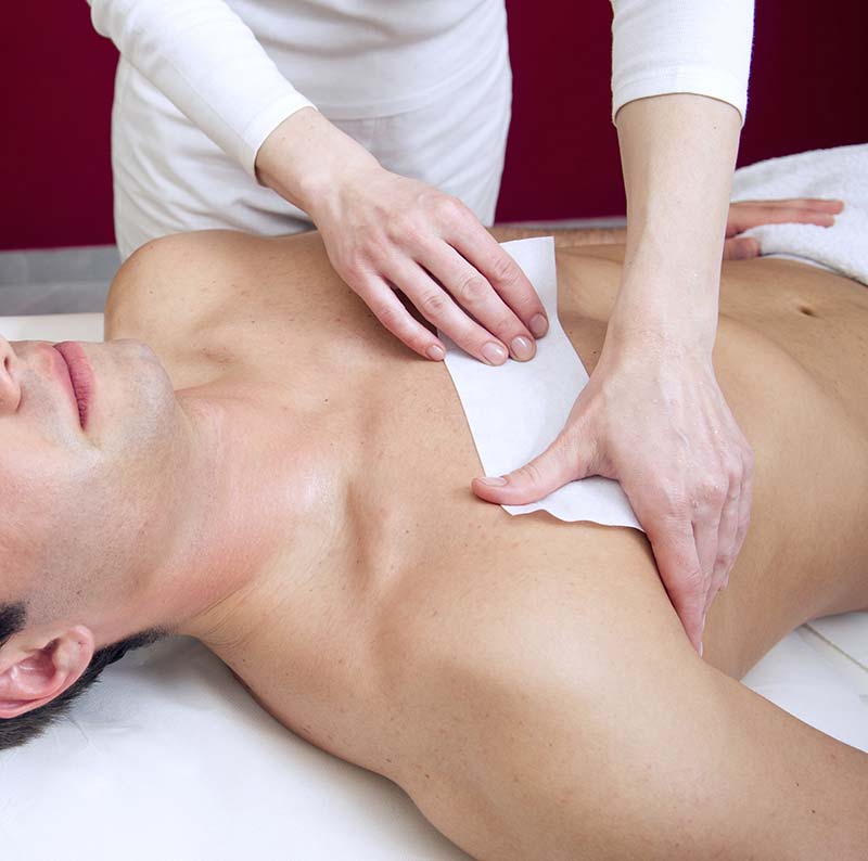 Man receiving waxing in spa