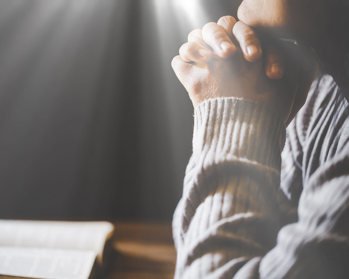Prayer hands over a Bible - Levittown Christian Church