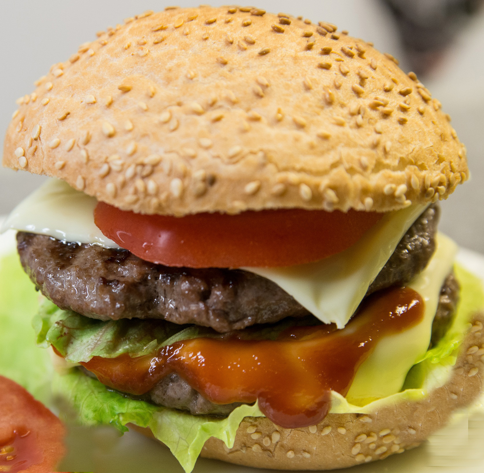 Rica Hamburguesa con Doble Carne de Res, tomate, lechuga, cebolla, american Cheese, Aderezada con catchup, salsa cheedar y mayonesa.