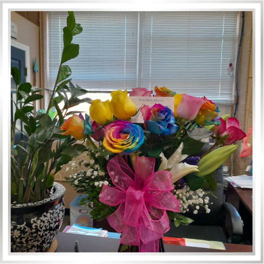 Bouquet of multi-colored roses in a red vase Bouquet of multi-colored roses in a red vase