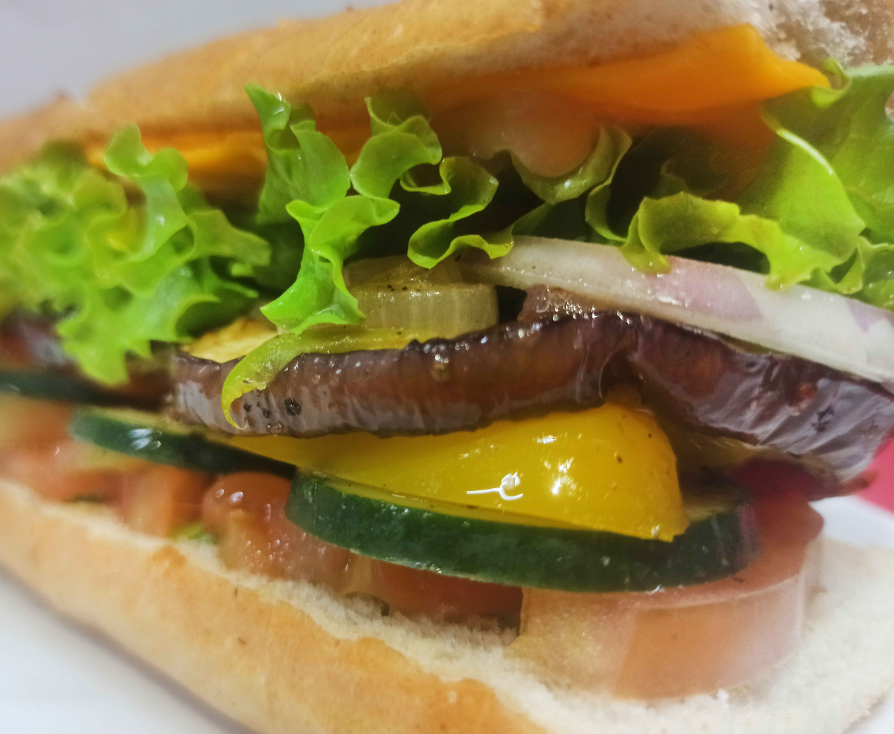 Sandwich en pan frances, queso danes, tomate, lechuga, pepino, berenjena, cebolla, pimientos marinados y un delicioso aderezo de mostaza y mayonesa.