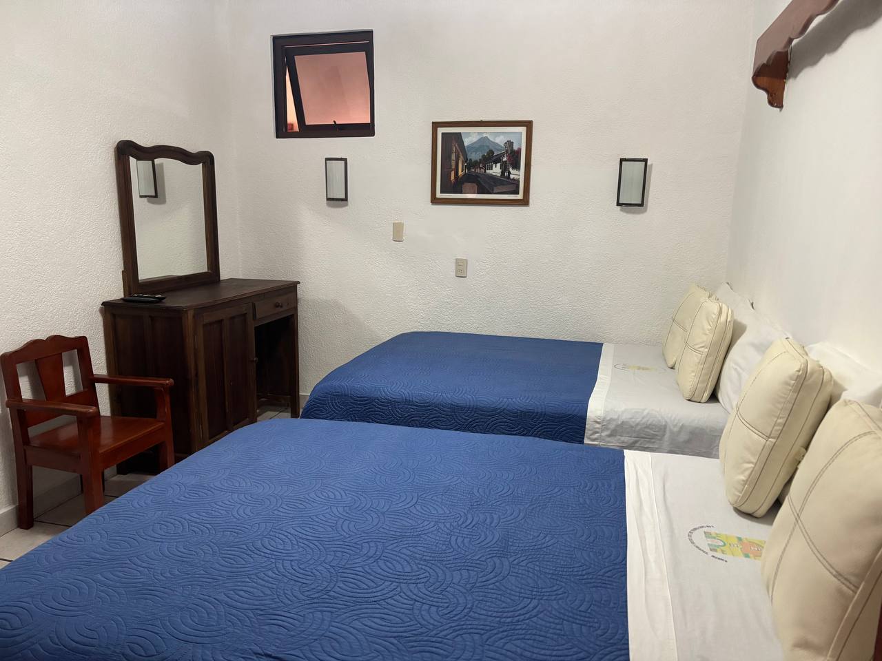Vestíbulo moderno de hotel de lujo con recepción, sillones naranjas, grandes ventanales y personas de negocios