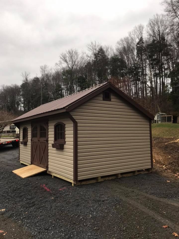 12 x 20 New England Deluxe Quaker in Vinyl                                      
                                                              
Featuring khaki colored vinyl siding, charcoal brown trim, a upgraded brown metal roof, 1- pair of vinyl flower boxes, Classic gable vents, 6’ brown colored Heritage door, 2- upgraded Heritage windows, 6’ treated ramp,
5- treated perpendicular 4x4 leveling runners