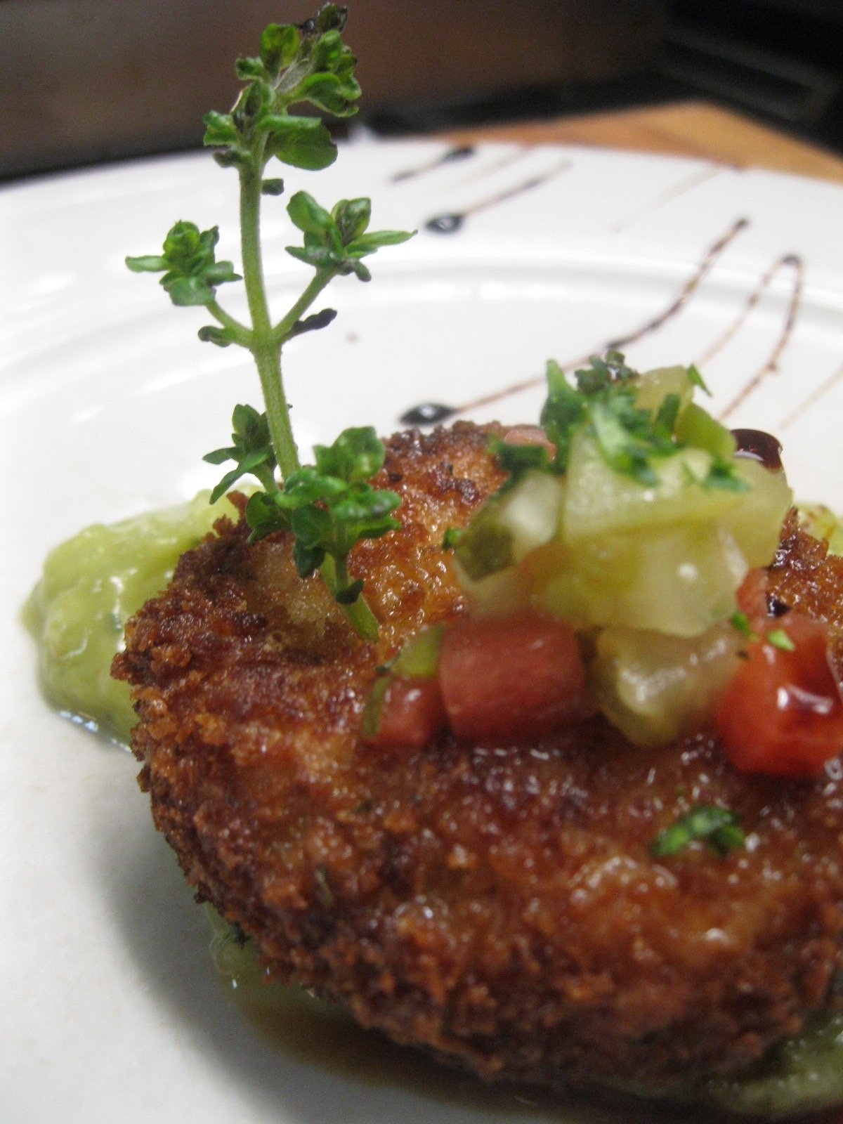 Maryland style crab cake with an heirloom tomato Jalapeno flecked concasse and avocado tartar sauce