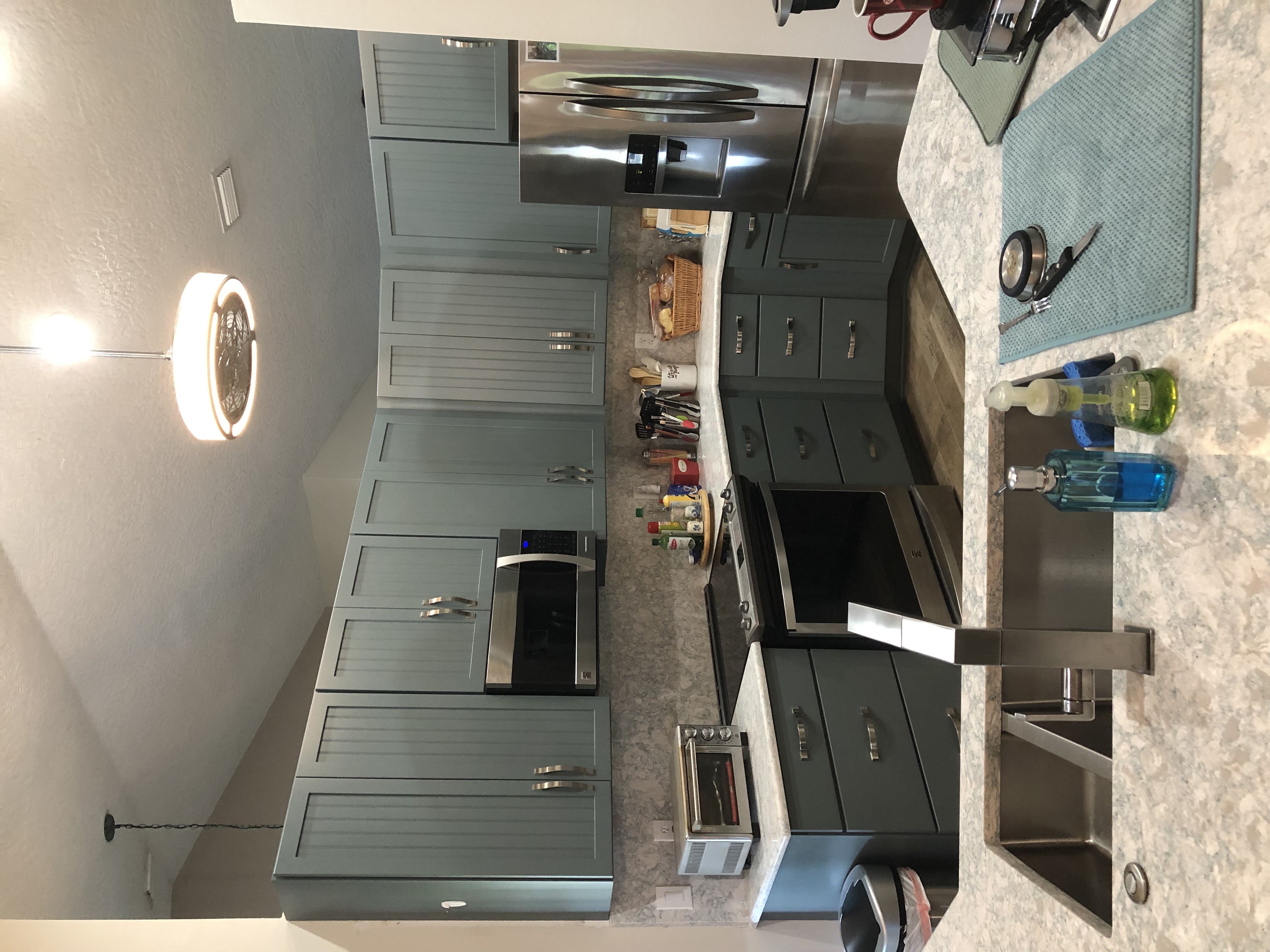 Tranquil coastal kitchen featuring semi-custom beadboard painted cabinetry with Cambria quartz countertops and full backsplash.