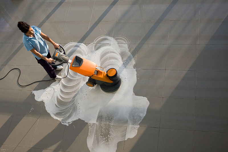 Worker is cleaning the floor with machine Worker is cleaning the floor with machine