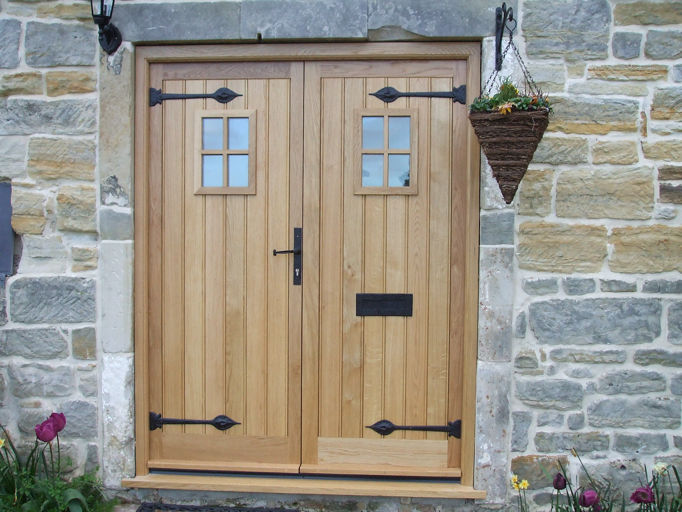 man in black t-shirt and gray pants standing near white wall