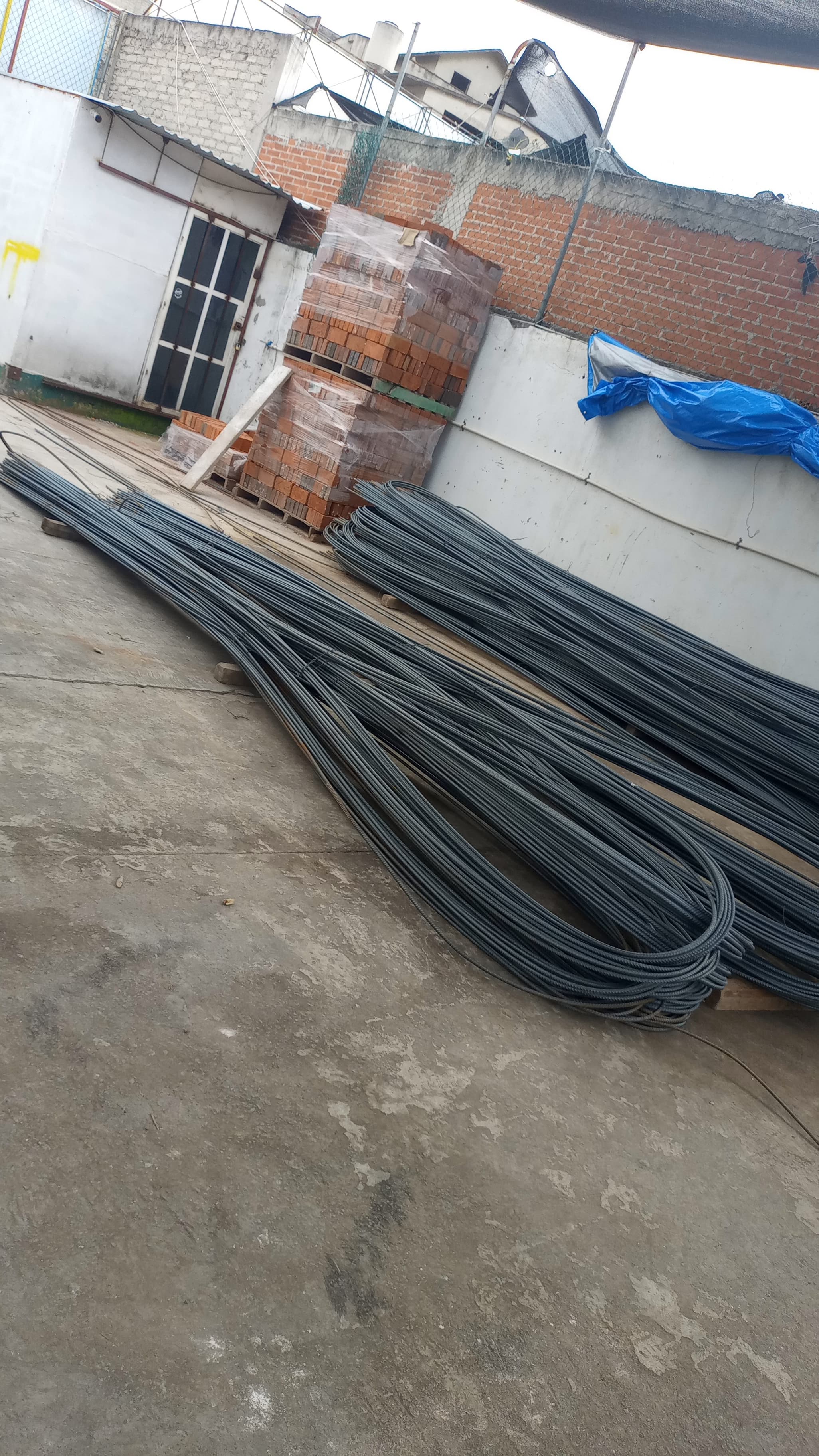 Almacén con estanterías llenas de toallas amarillas y grises, suelo de concreto pulido y amplia iluminación.