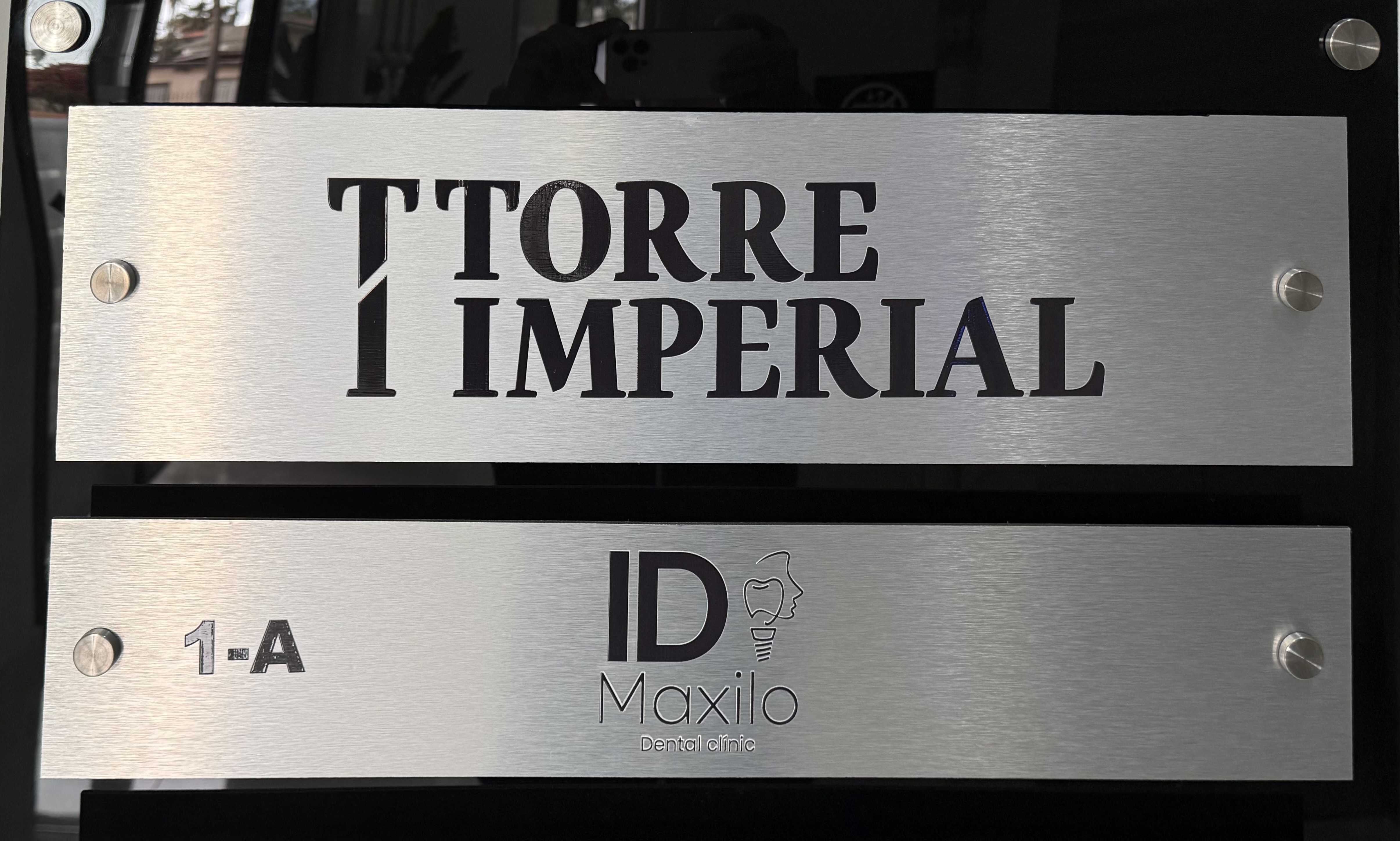 Consultorio dental moderno con silla y equipo odontológico, pantalla mostrando imagen dental, y texto 'Dental Services' en ambiente luminoso.