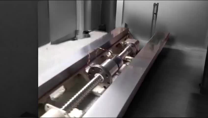 Máquina industrial con componentes mecánicos y tornillos a la vista, en un entorno de metal pulido.