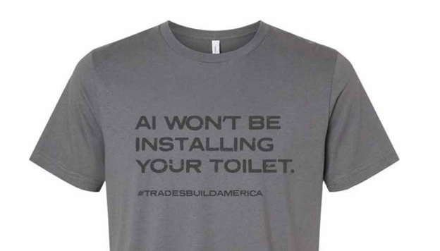Gray t-shirt with text 'AI Won't Be Installing Your Toilet' and hashtag '#TradesBuildAmerica'.