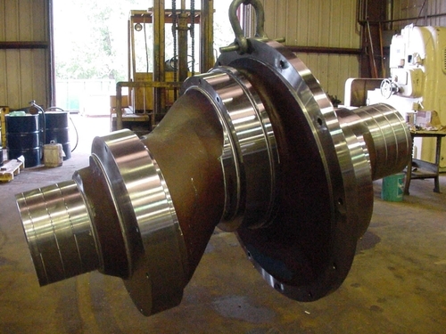 Engineer working with industrial machinery in a modern manufacturing facility, focused and wearing protective gear.