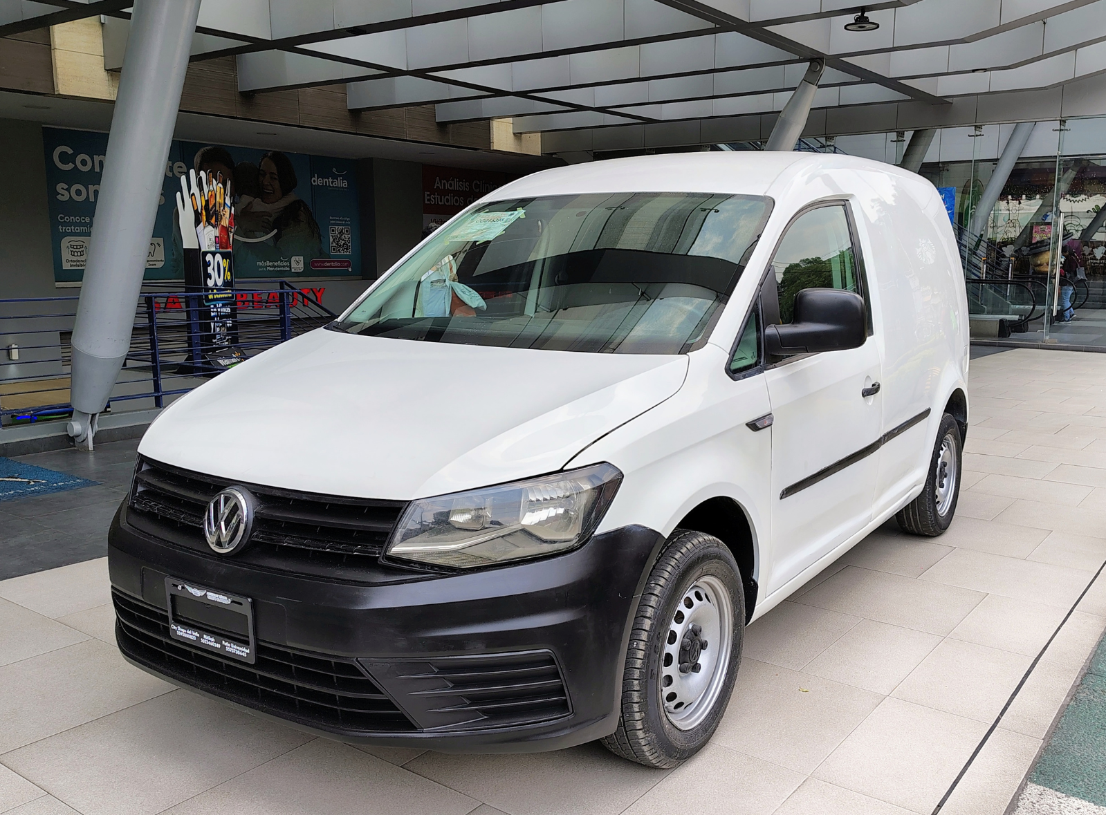 Primer plano de la llanta de un auto deportivo azul en un taller iluminado.