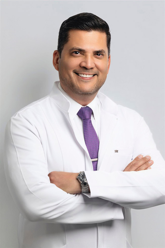 Headshot of Doctor Palacios in a white labcoat and purple tie