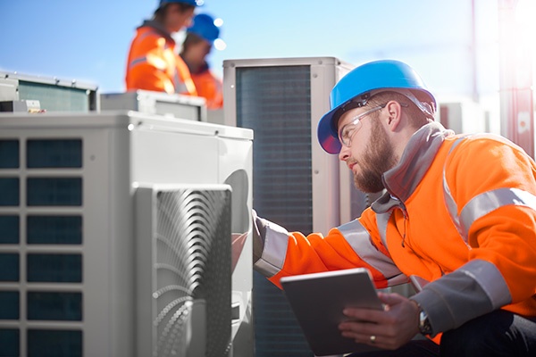 Engineer inspecting air conditioner Engineer inspecting air conditioner