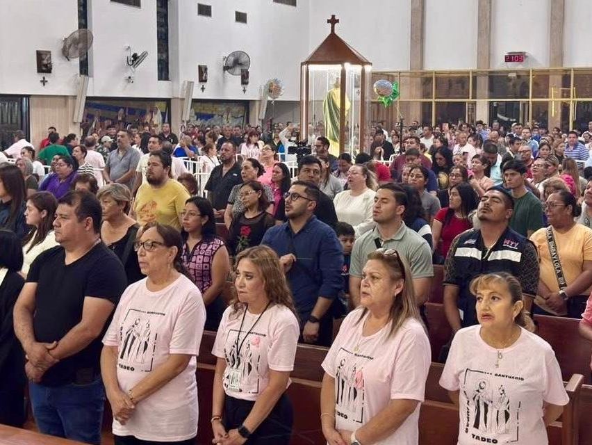 Dos hombres analizan datos en dos monitores con gráficos y mapas en una oficina moderna bien iluminada.