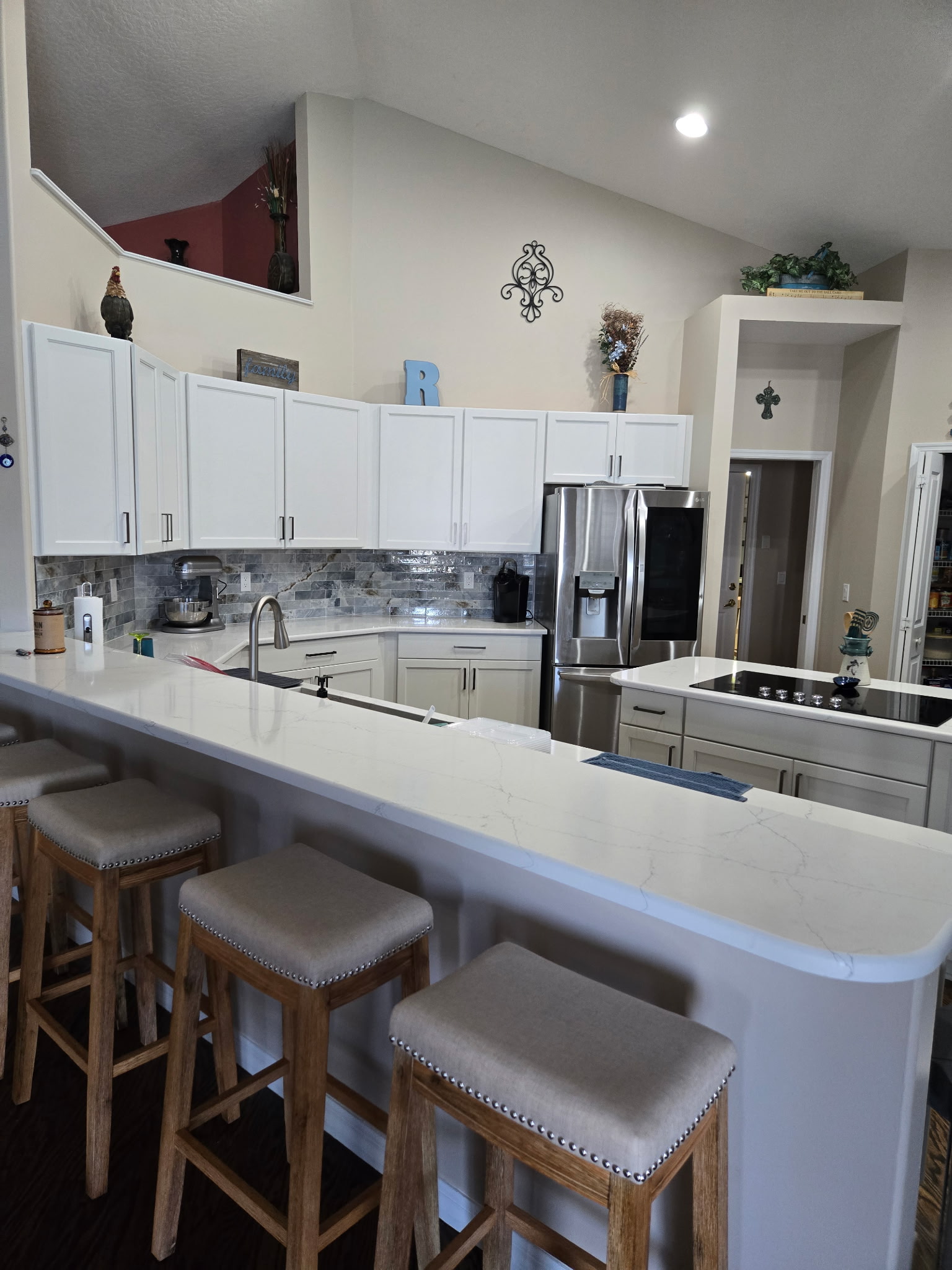 Spacious kitchen features beautifully crafted semi-custom cabinetry painted in a soft Steam finish, 
accented with brushed pewter handles, blending classic charm with modern style while offering ample storage.